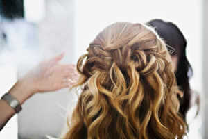 Makeup by Keturah putting finishing touches on brides hair