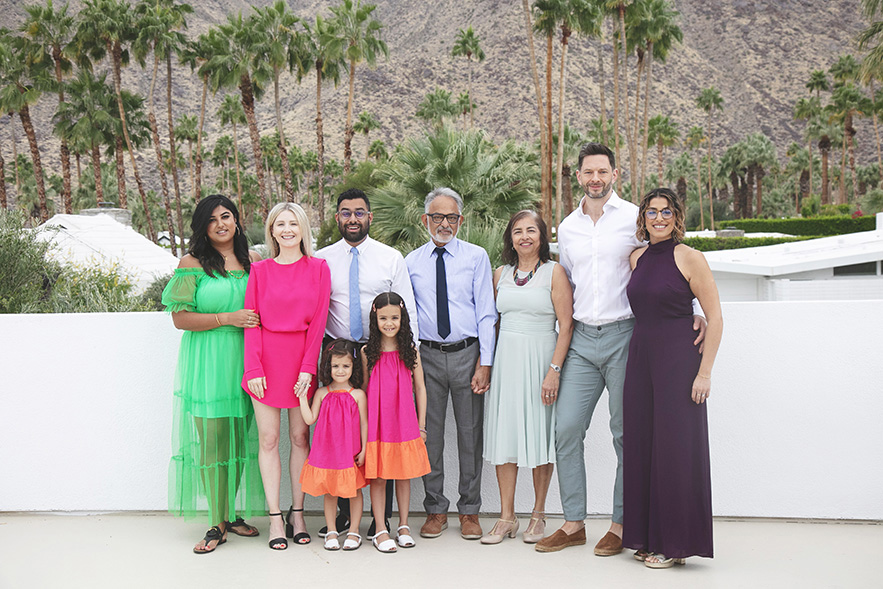 Extended family pose casually in front of mountain backdrop in colorful clothing