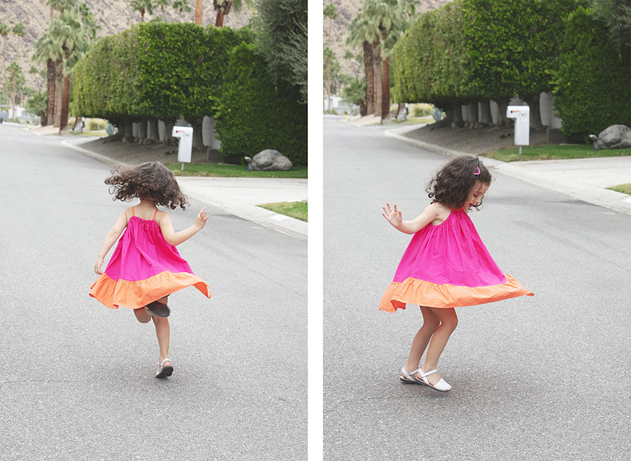 Young girl plays and twirls in the Palm Springs street.