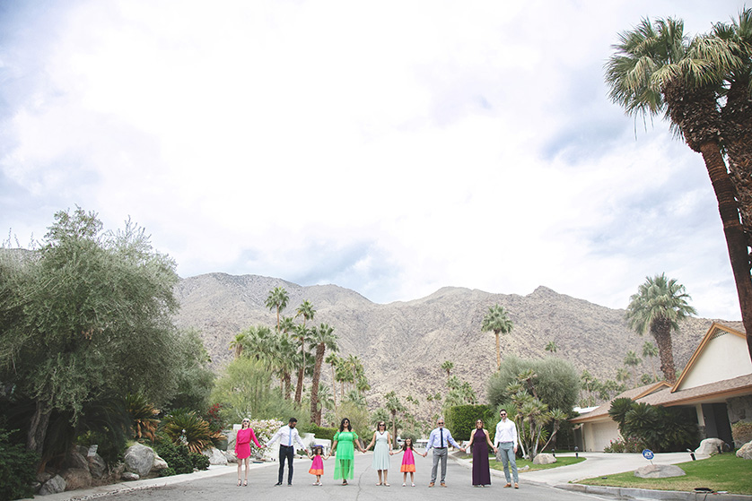 Family walking hand in hand towards the camera with moutains in the background