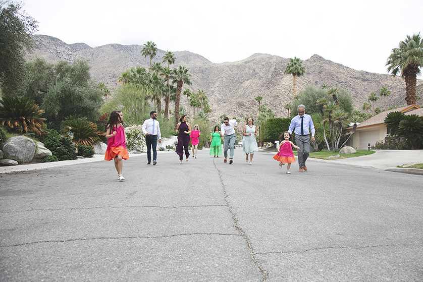 The entire extended family stretched out across the street stroll towards the camera