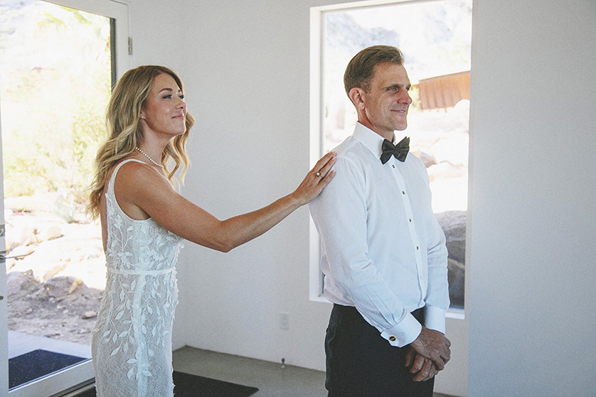 Bride taps groom on shoulder during first look moments