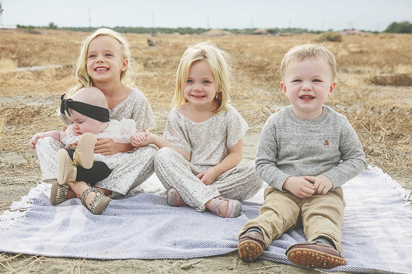 Palm Springs photo session including four young children seated on a blanket in the desert