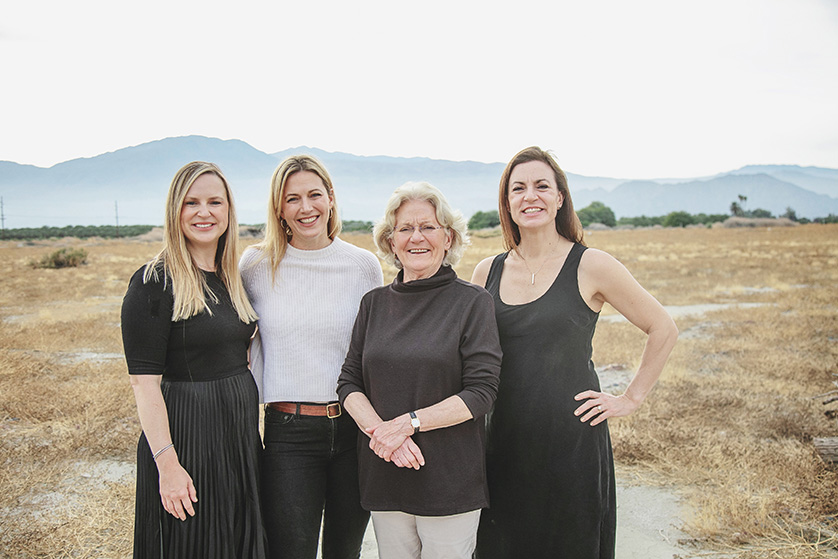 Mother and her adult children pose casually in the Palm Springs desert