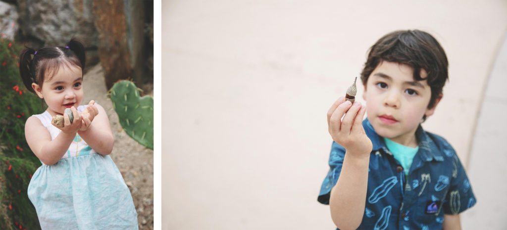 Toddlers holding out found treasures to show the photographer