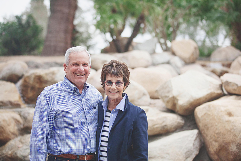 Grandma and Grandpa pose for a relaxed photo in front of desert rocks