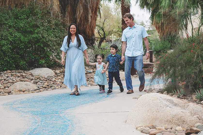 Sweet young family of four stroll through the desert park