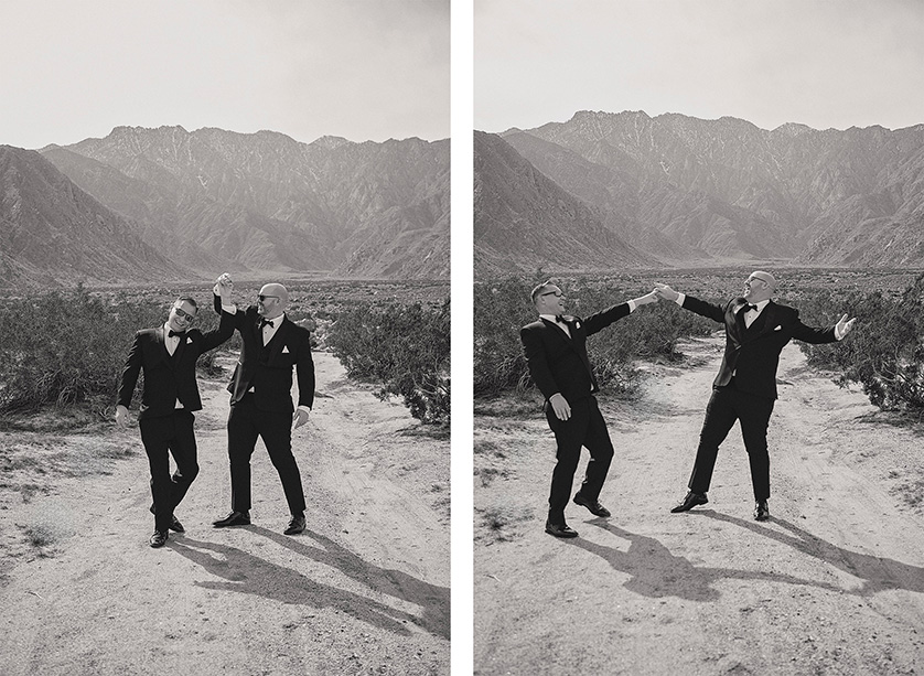 Two grooms dancing in the desert and having fun.