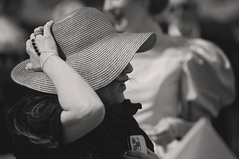 A guest at the Joshua Tree elopement holds on to her hat in the wind