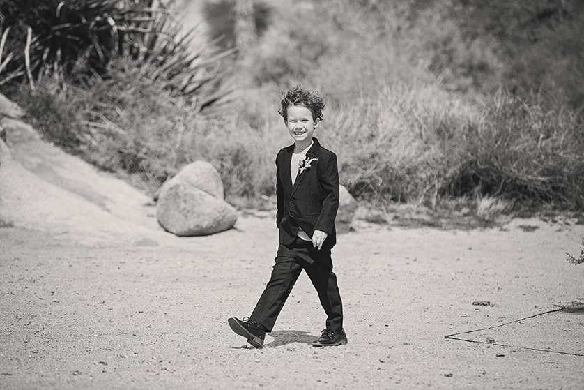 A candid black and white photograph of the brides son and ring bearer walking through Joshua Tree