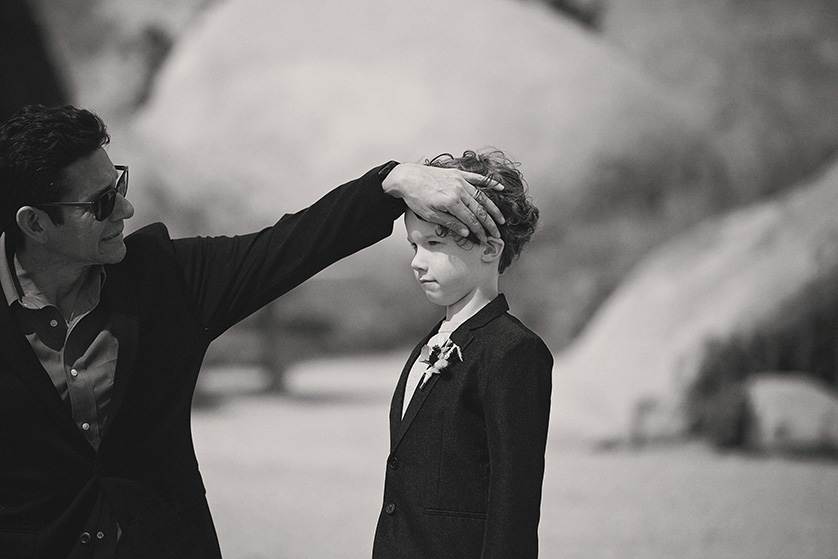 A documentary style photograph of the ring bearer having his hair fixed