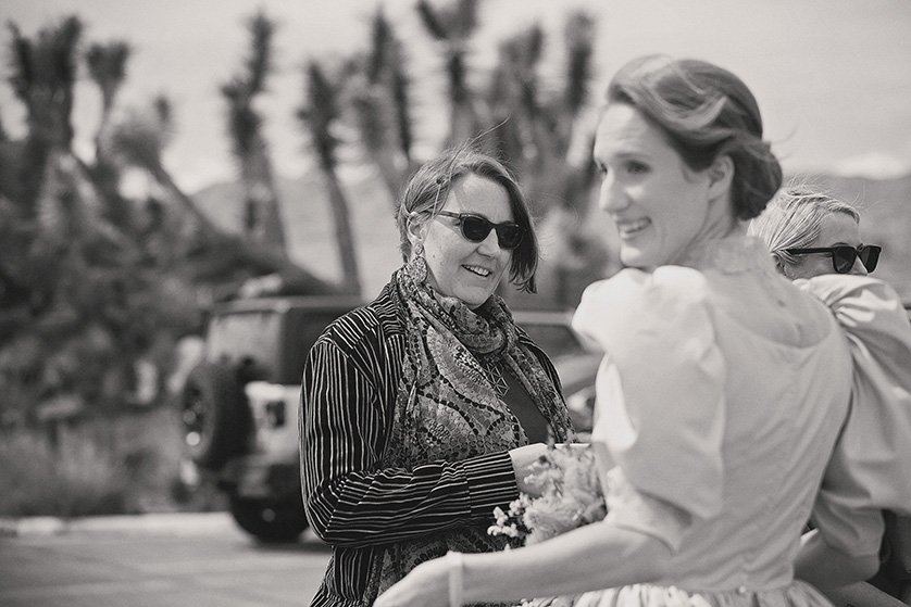 Candid black and white of a bride meeting her guests in Joshua Tree