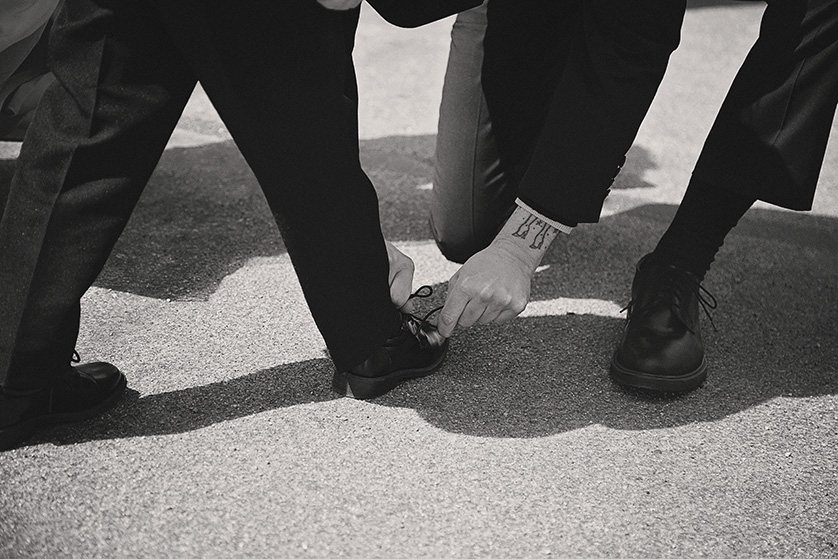 A photo of the ring bearer having his shoes tied before the ceremony in Joshua Tree, Ca.