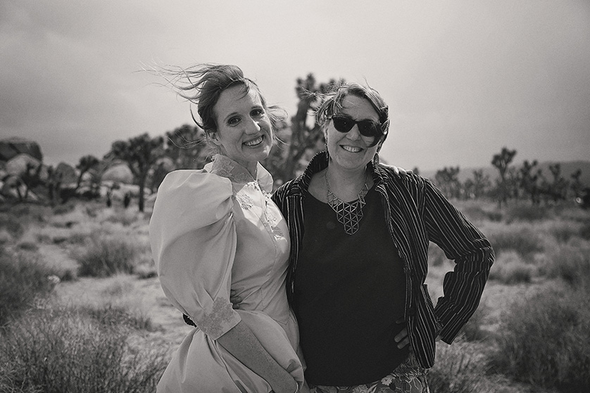 A windy candid photo in black and white, the bride and a dear friend