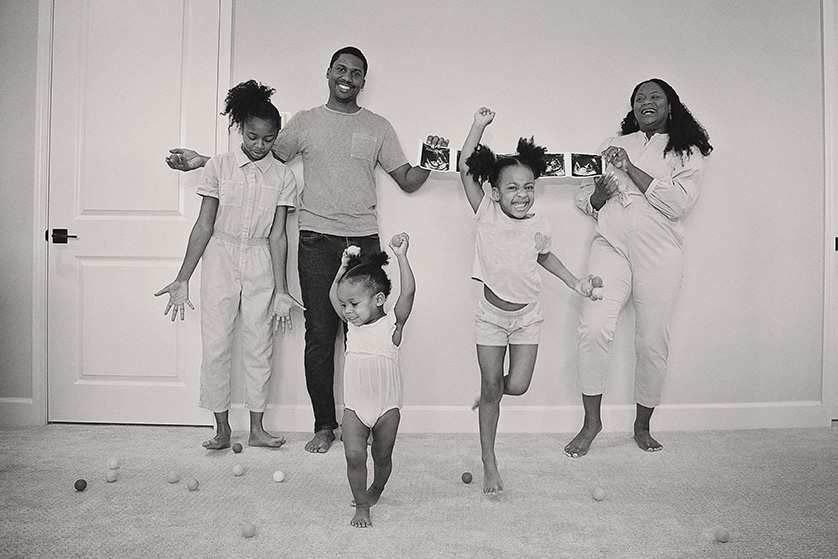 A black and white photo of a family announcing a new baby on the way.