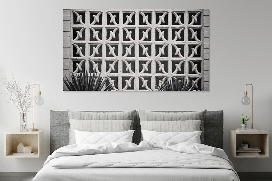 Classy grey bedroom with dramatic photograph of palm springs breeze blocks on the wall