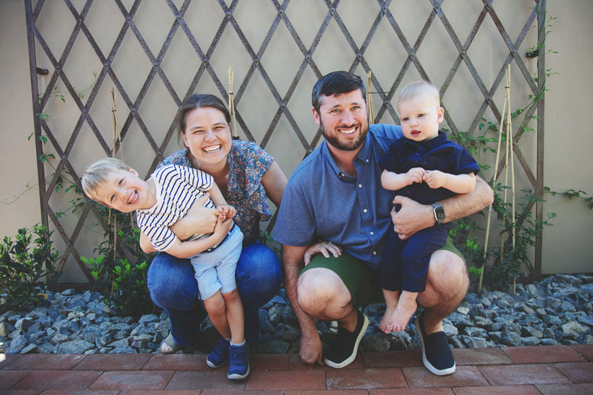 Parents and their two boy toddlers smile and act goofy for a fun family portrait