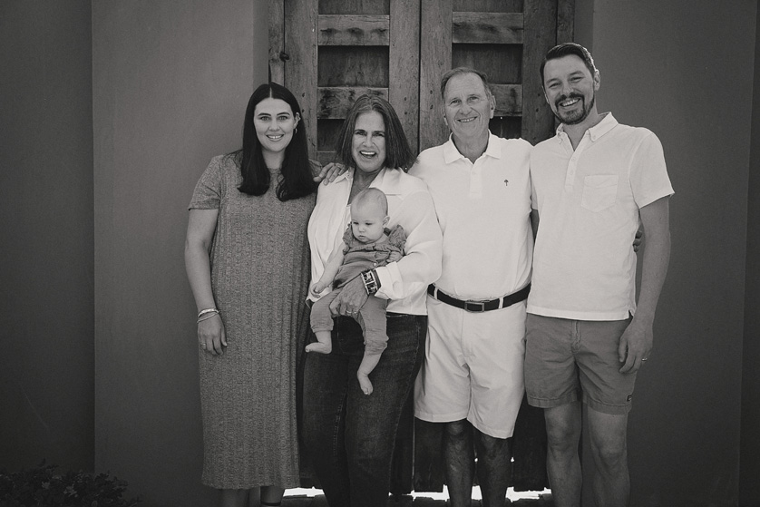 Black and white family photo in front of rustic doors in la quinta, ca