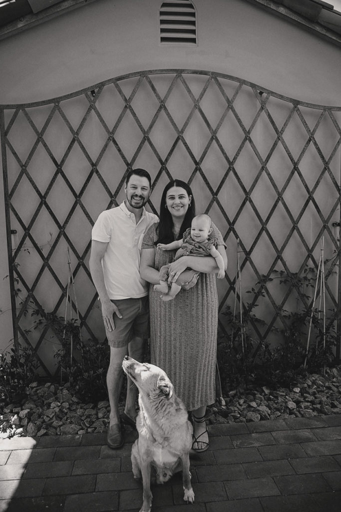 Family portrait in black and white, with family dog in the garden