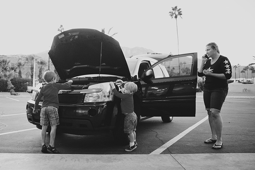 documentary style black and white photograph of mom and her two young sons