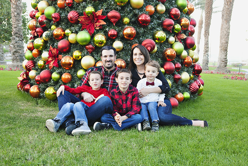 Family posing in front of a large decorated Christmas tree outdoors.

Keywords: family, Christmas, holiday, tree, decorations, ornaments, festive, outdo