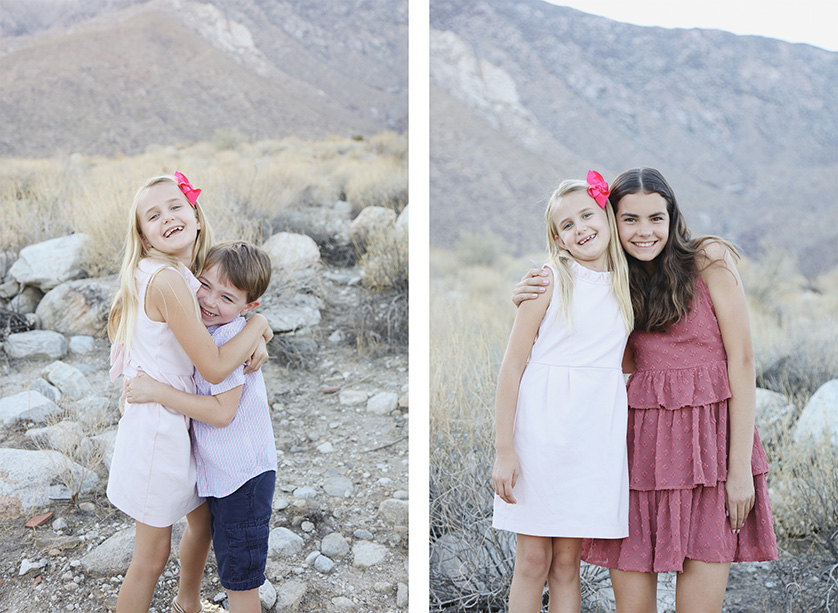 Two children hugging in a dry, rocky desert landscape.