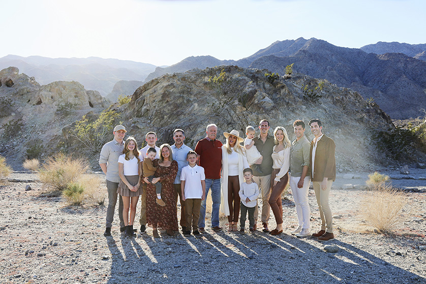 Large family group pose for family photo in bright desert landscape