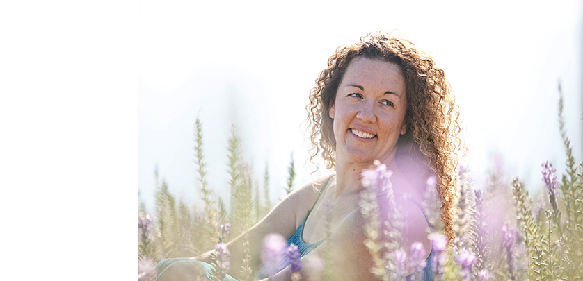 Clean fresh portrait of a woman in a field of flowers