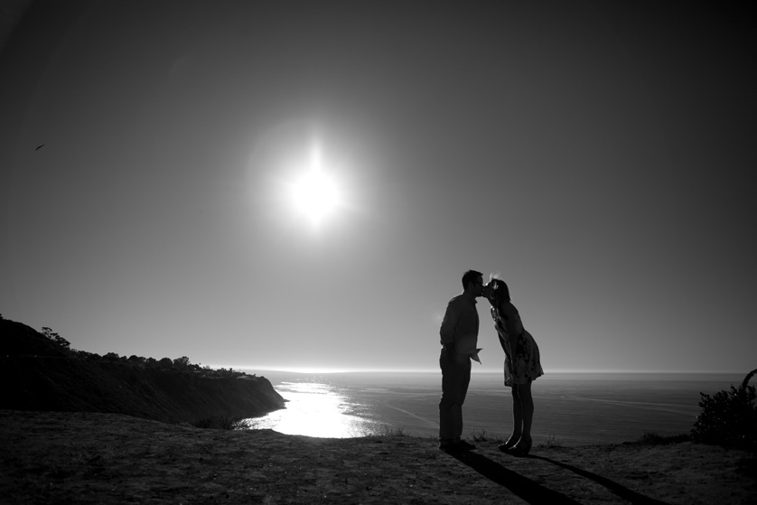 Silhouette of couple kissing on the cliff overlooking the ocean