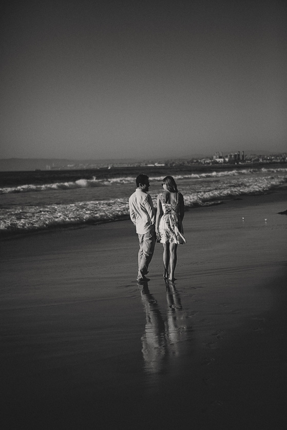 Black and white photo of couple walking on the beach