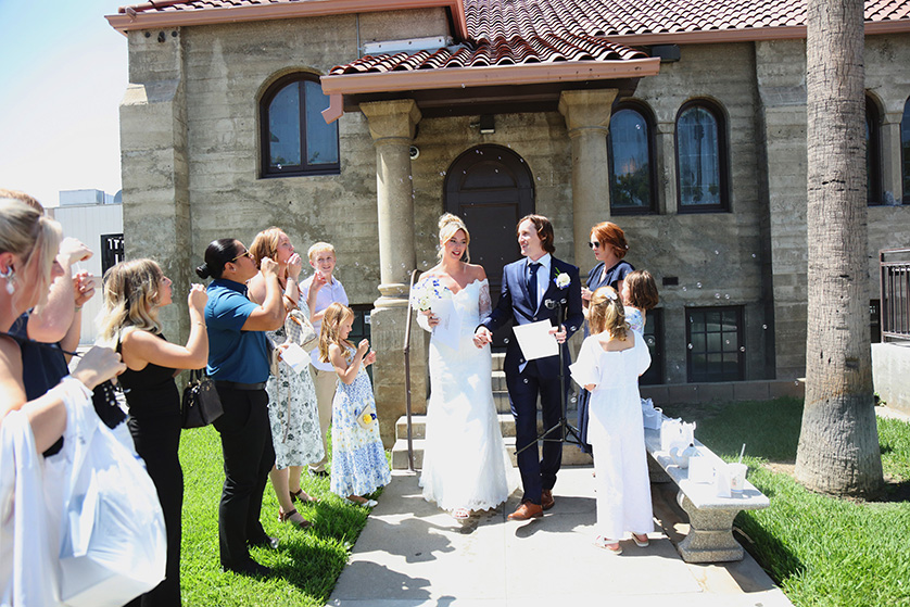 bride and groom leaving church with guests blowing bubbles