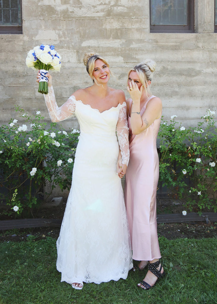 bride poses with her emotional bridesmaid