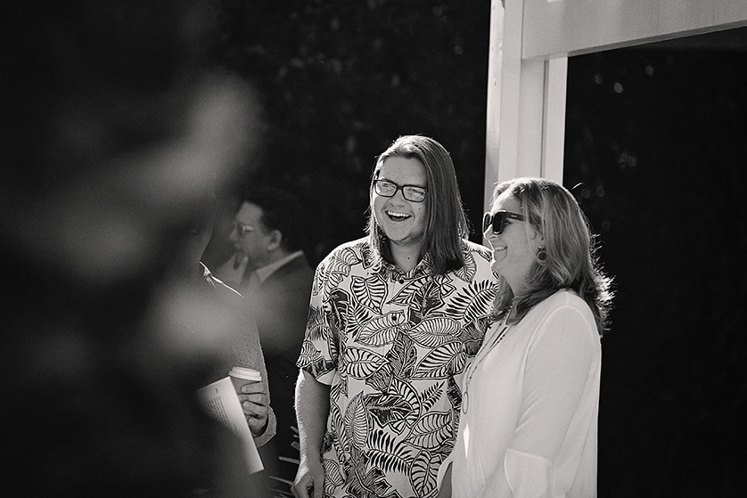 Wedding guests laugh and mingle during a sunny backyard ceremony in Palm Springs.