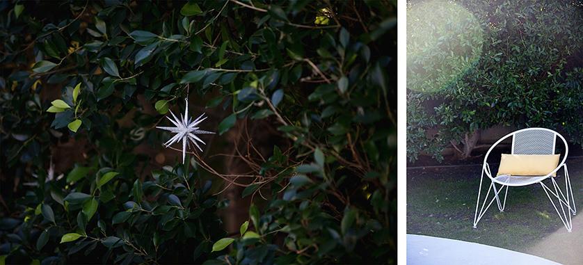 Silver starburst ornament hangs in greenery; mid-century modern white chair with yellow cushion sits by the pool.