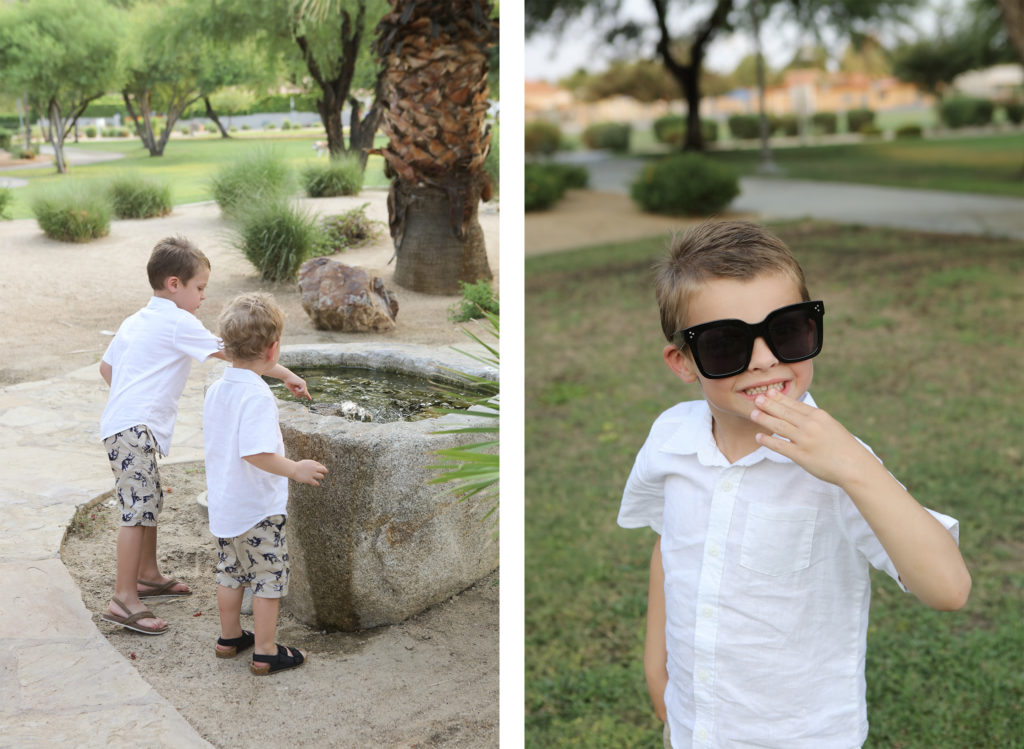 Two young boys toss pebbles into a stone water fountain in a desert garden, while one of the boys later poses playfully wearing oversized sunglasses.