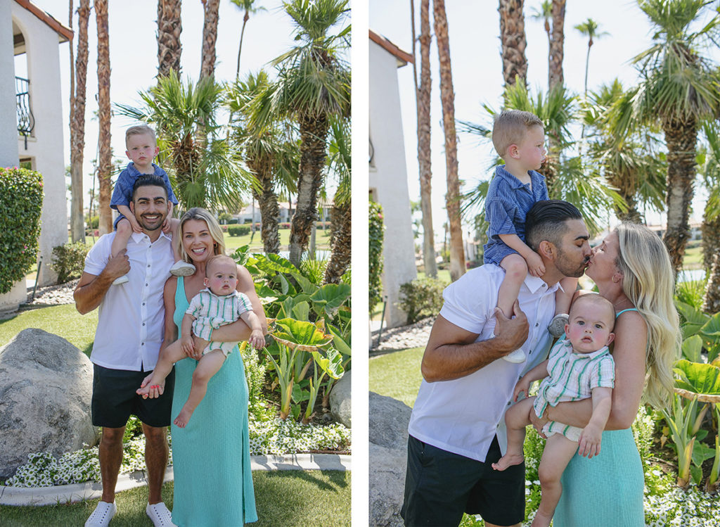 A smiling family of four poses in Palm Springs with palm trees and greenery in the background.