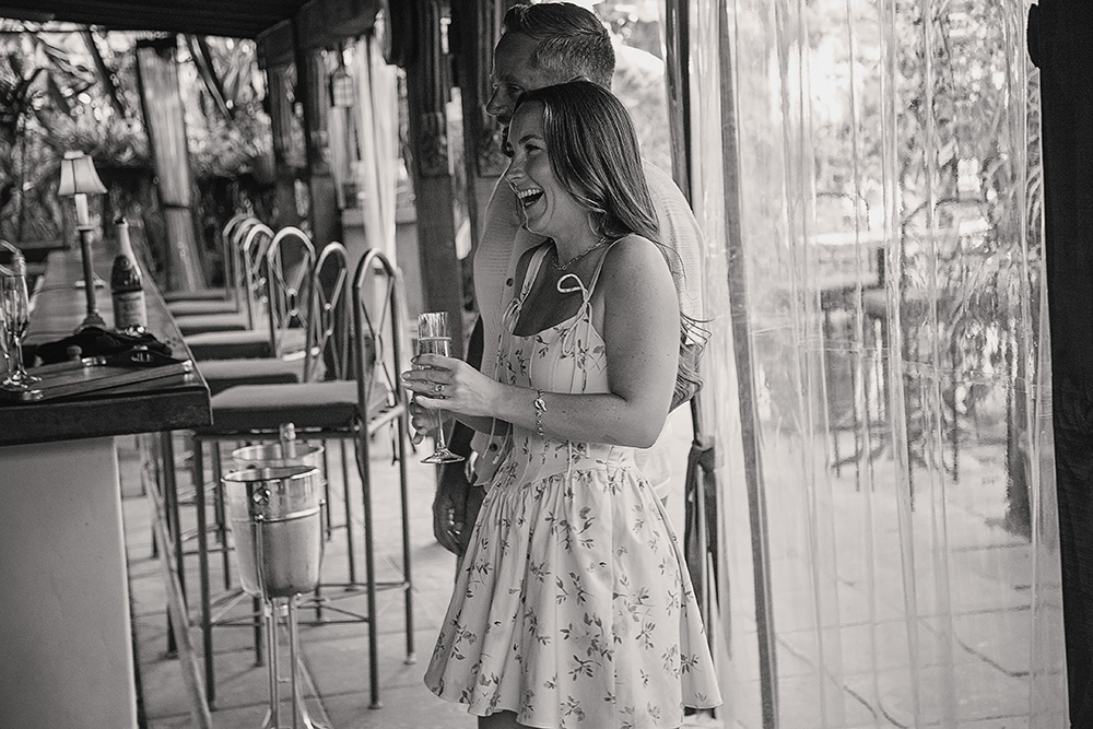 A woman laughs with happiness while holding a champagne glass, celebrating her engagement at Casa de Monte Vista in Palm Springs.