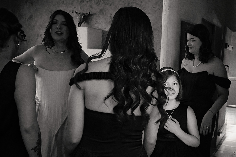 Bride surrounded by bridesmaids and flower girl while getting ready at Bubbling Wells Ranch, captured in black and white documentary wedding photography