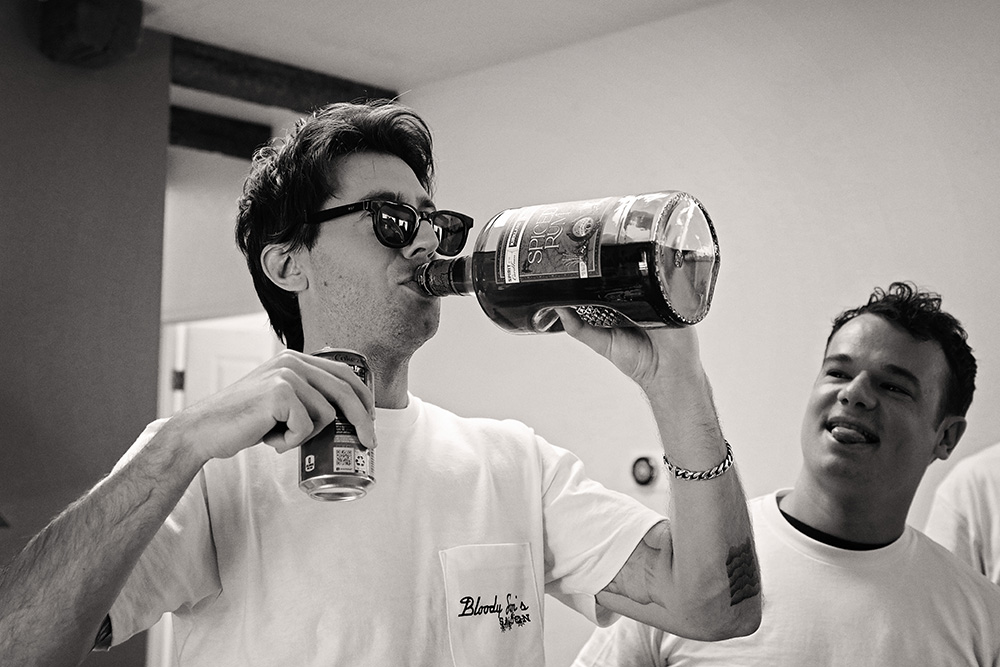 Groomsmen sharing drinks and laughter while getting ready at Bubbling Wells Ranch, captured in black and white documentary wedding photography