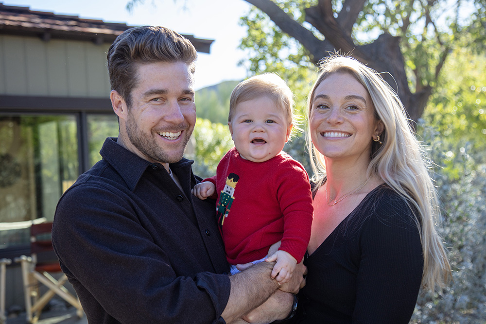 Palm Springs family portrait of smiling parents holding their baby during a relaxed outdoor family photography session in California