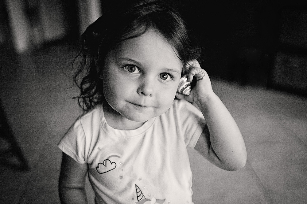 Toddler looking directly at the camera inside the home during a documentary day in the life family photo session.
