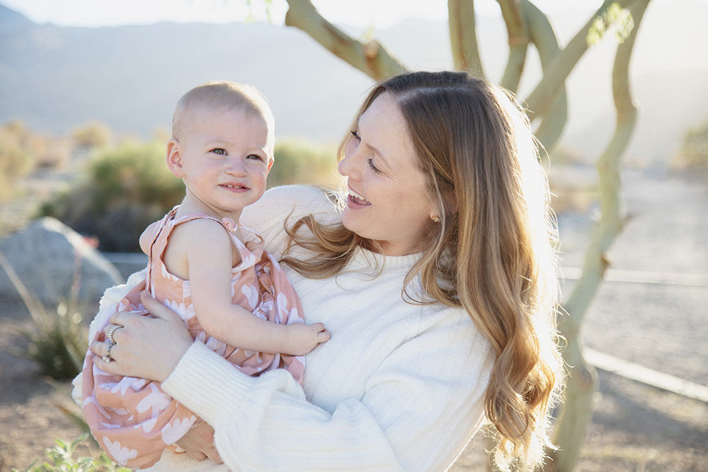 Mother smiling at toddler during natural light family photos in La Quinta Cove