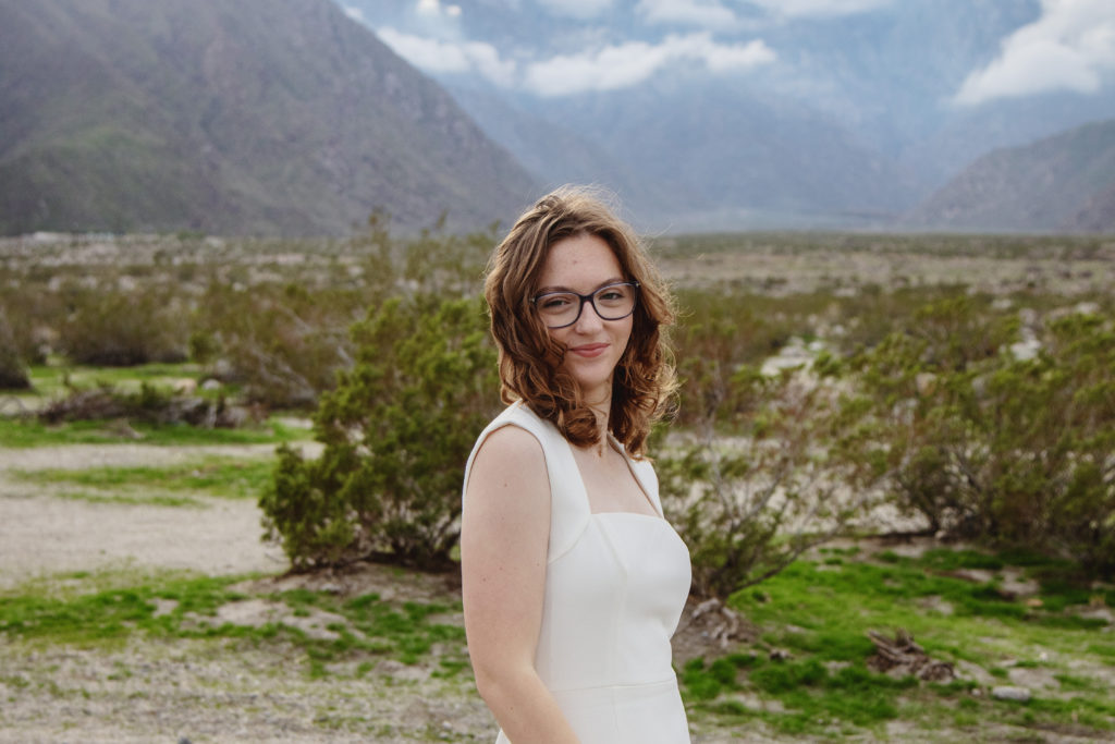 Sweet portrait of a teenager with dramatic desert scenery behind her