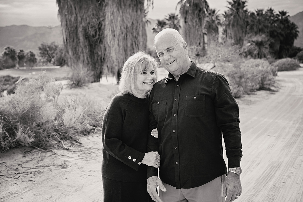 Older couple poses for a casual portrait in the desert.
