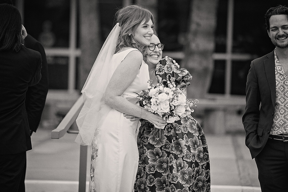 a bride and her close friend share a sweet hug in congratulations