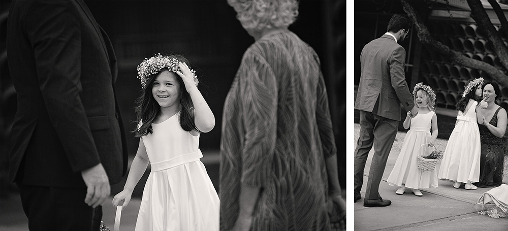 Black and white photo of the flower girl happily showing of her flower crown.