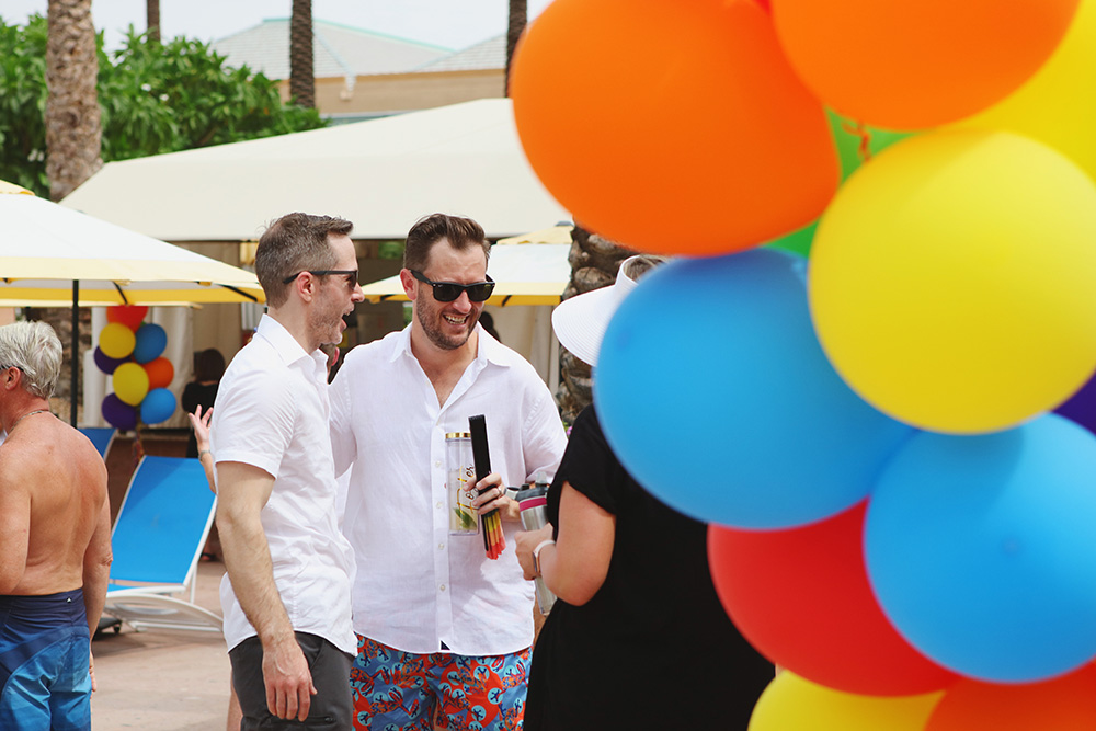 Candid image of guests enjoying a pool party with bright balloons