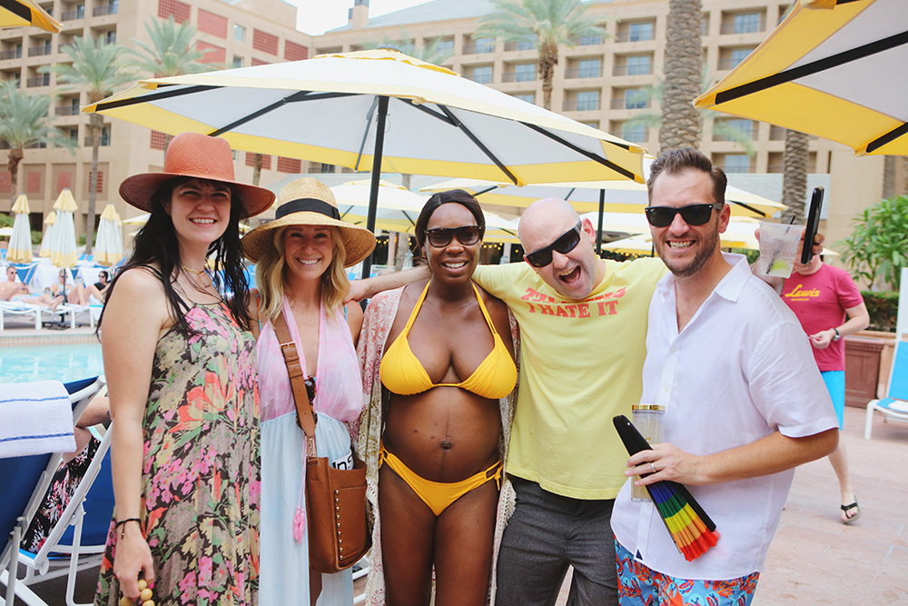 Group of guests in swimsuits pose for a fun photo