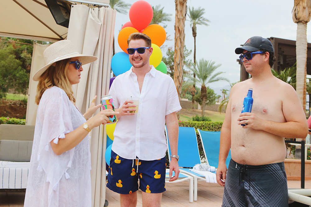 Guests mingle around the pool at wedding welcome part