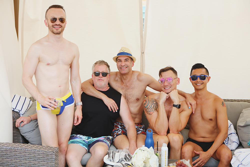Group photo of friends in a pool cabana